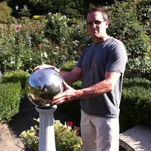 Bruce B caressing a stainless steel garden ball at the beautiful Butchart Gardens in Victoria BC Canada.